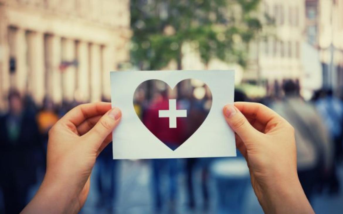 person holding a piece of paper with a heart