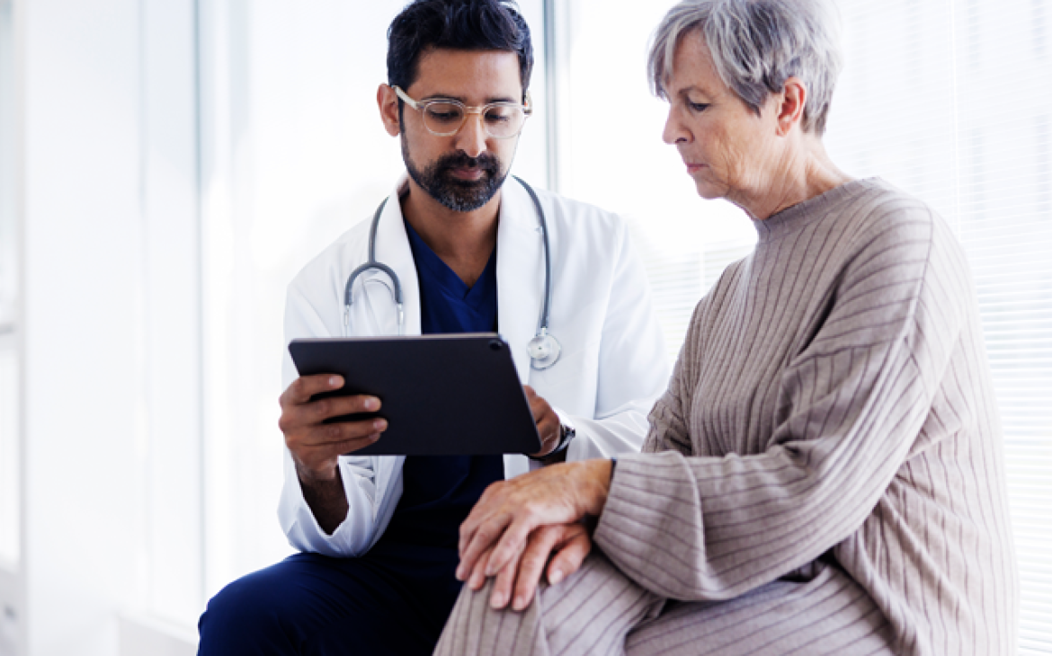 Doctor looking at a tablet with a patient
