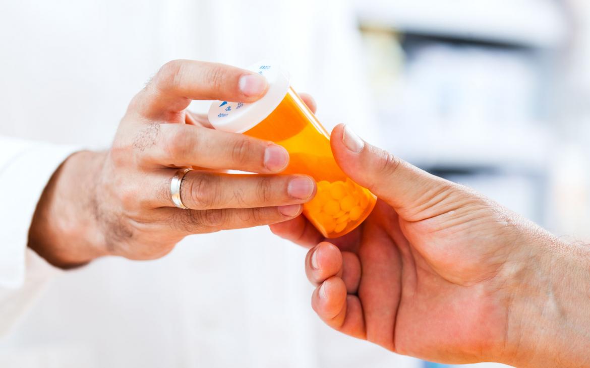 Pharmacist gives prescription to patient