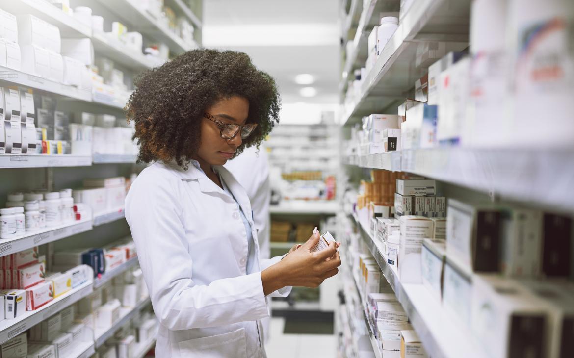 Pharmacist reads pill bottle